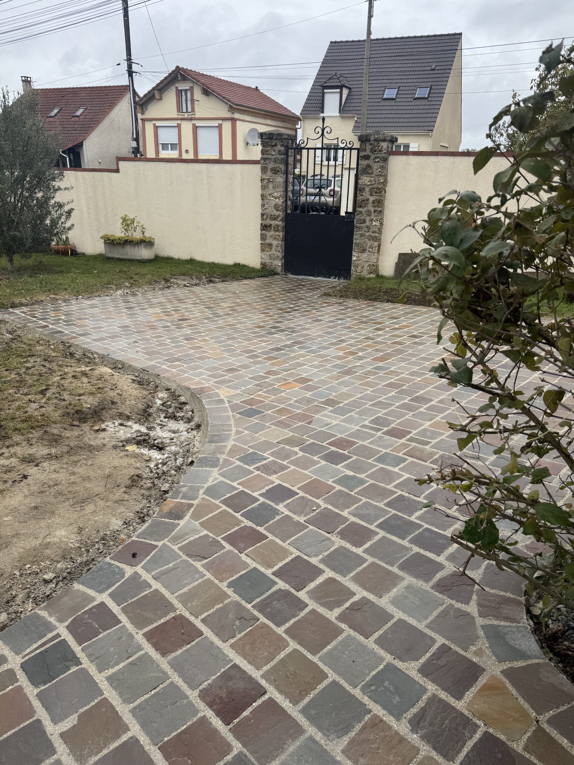 Cour pavée en pierre naturelle devant portail à Rungis